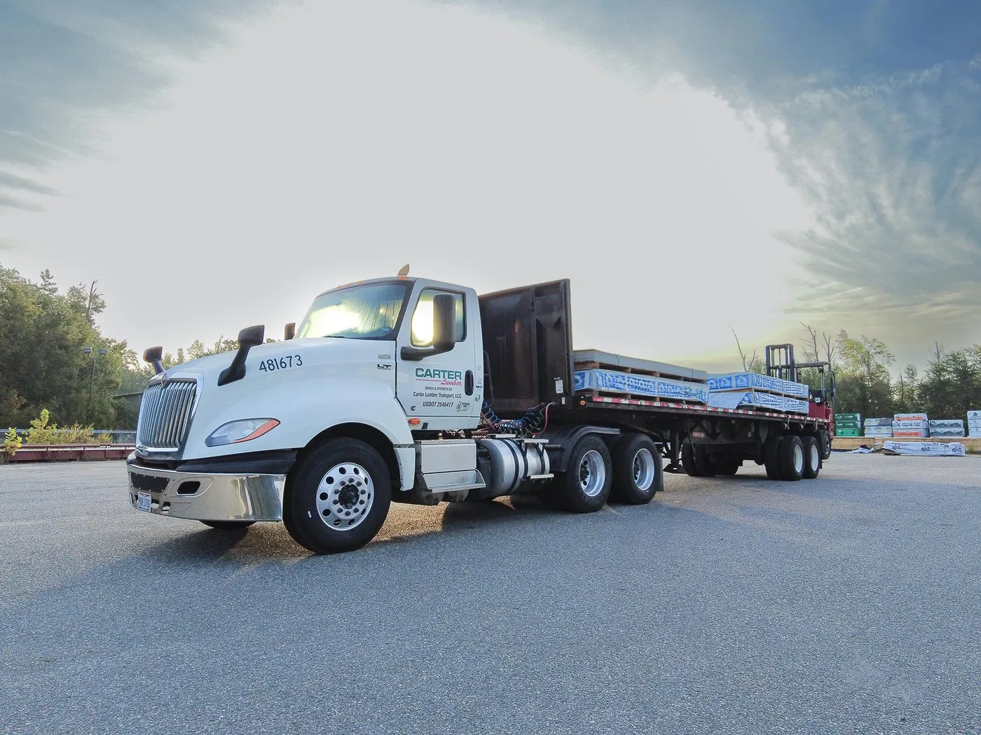 Carter Lumber flatbed truck loaded with materials in a lumber yard at sunrise