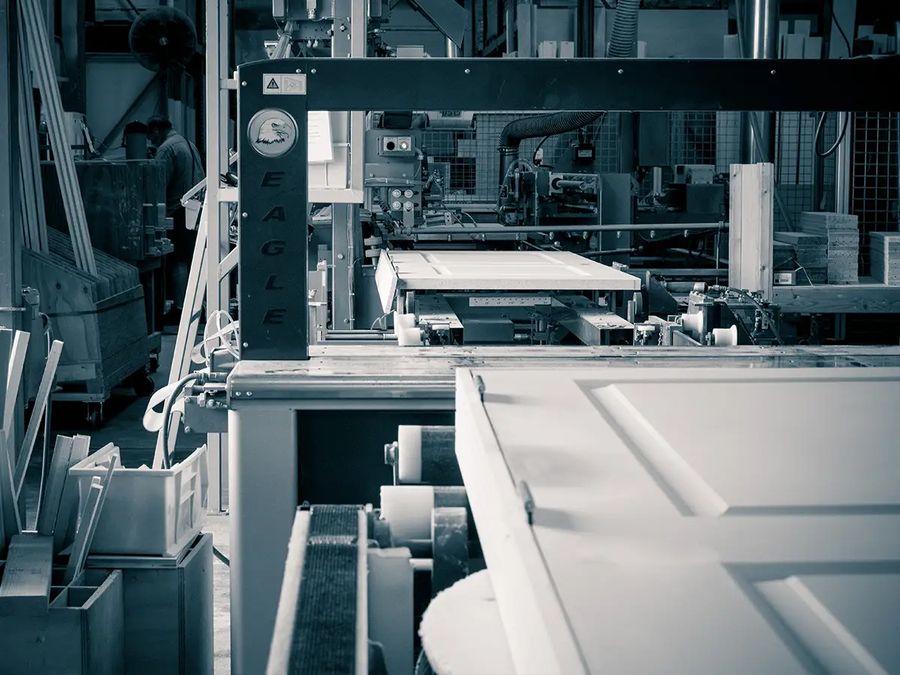 Interior door panel moving through a machining line in a millwork shop