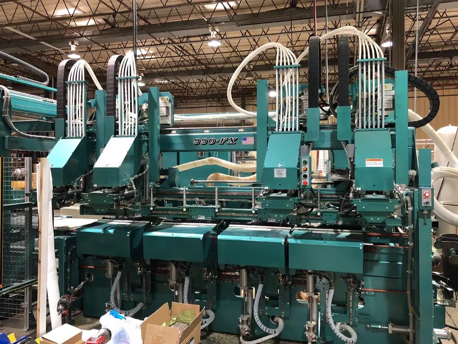 Large green automated door machining equipment in a millwork shop