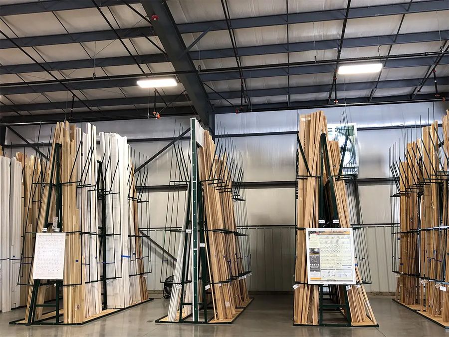 Trim boards stored upright in green A-frame racks in a warehouse