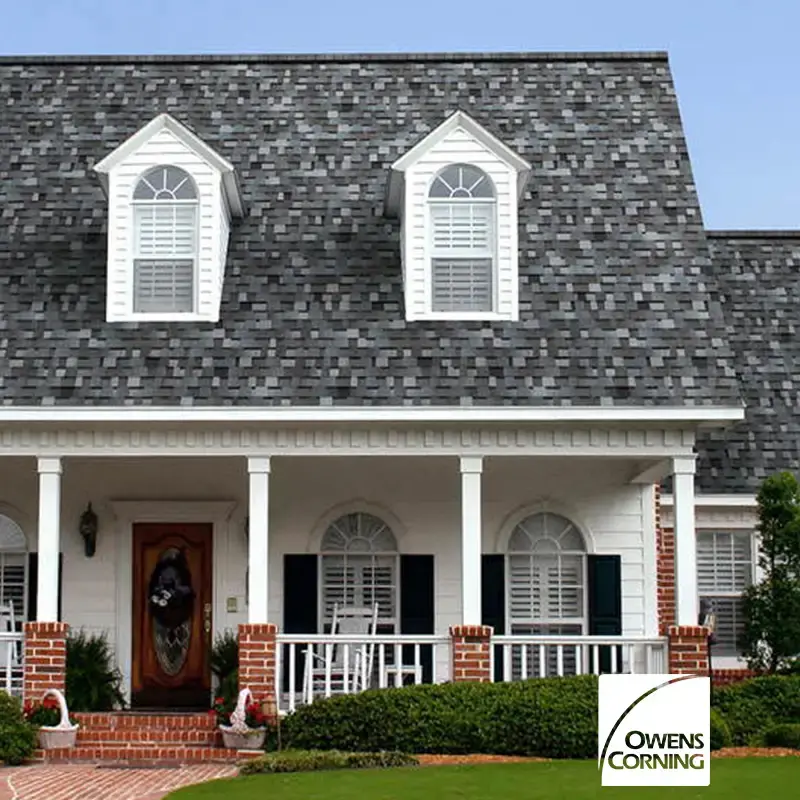 White Cape Cod home with gray shingle roof and dormers, with Owens Corning logo