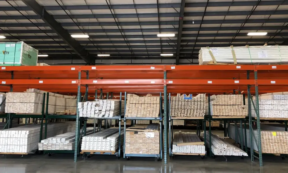 Warehouse pallet racks loaded with bundled white moulding and trim