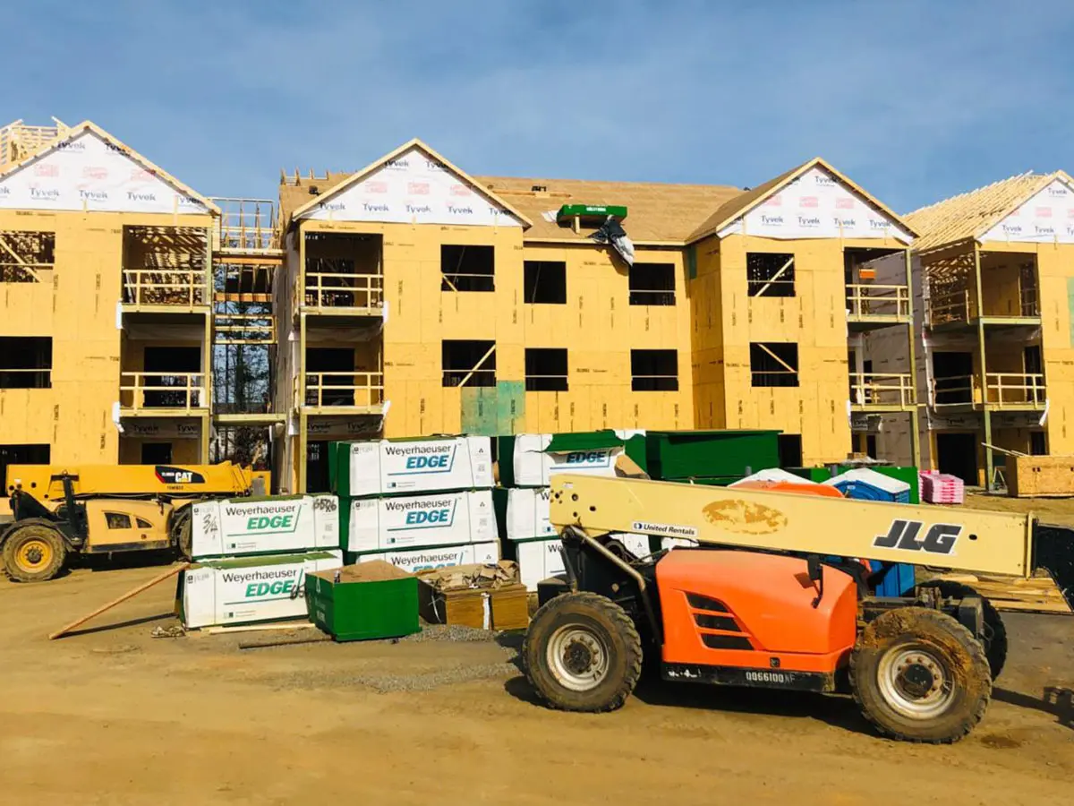 Apartment buildings under construction with Weyerhaeuser Edge materials and a JLG telehandler