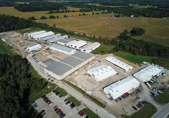 Aerial view of a manufacturing campus with several large buildings surrounded by farmland